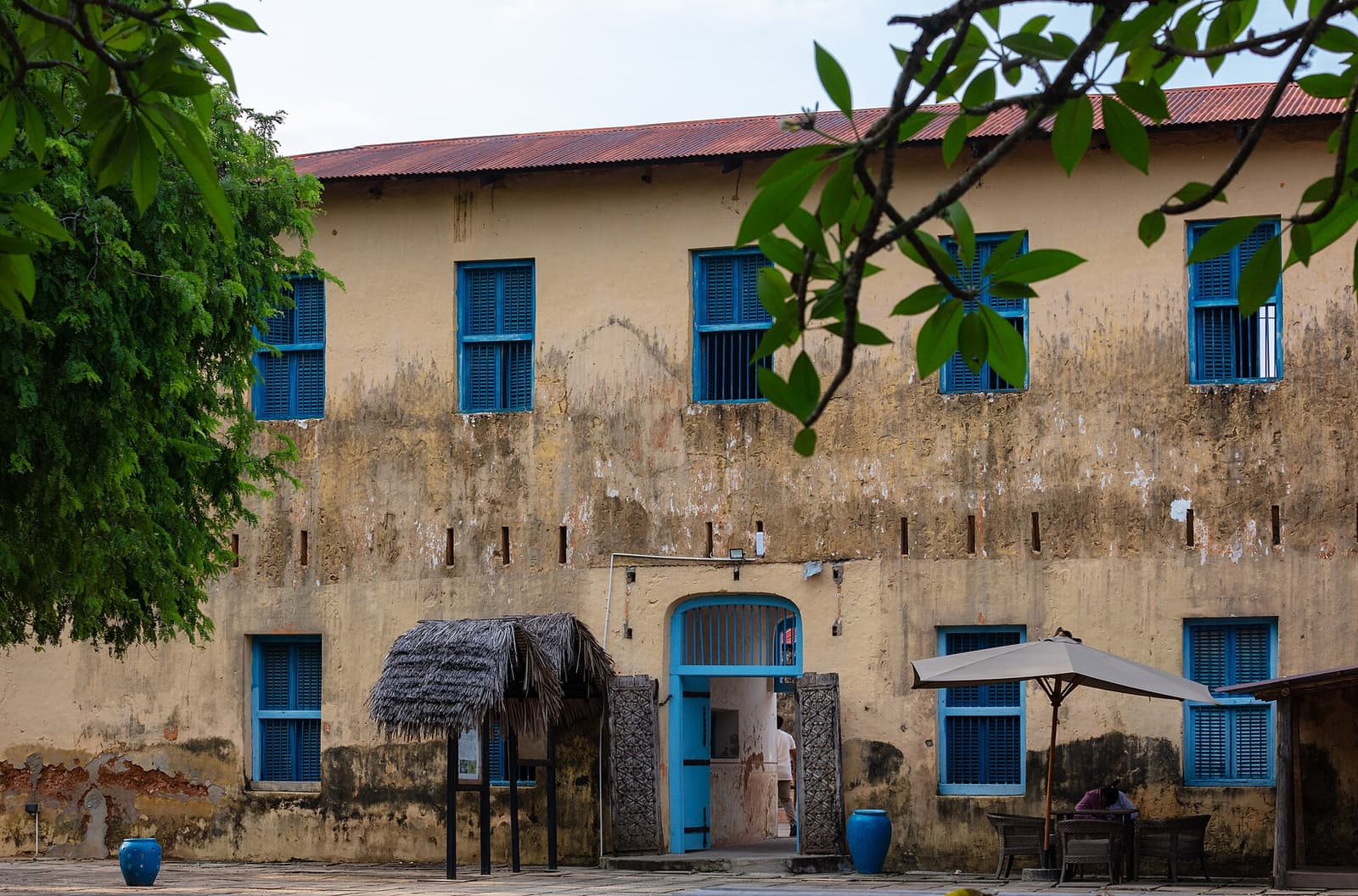 The old prison building on Changuu Island with blue shutters and a red roof